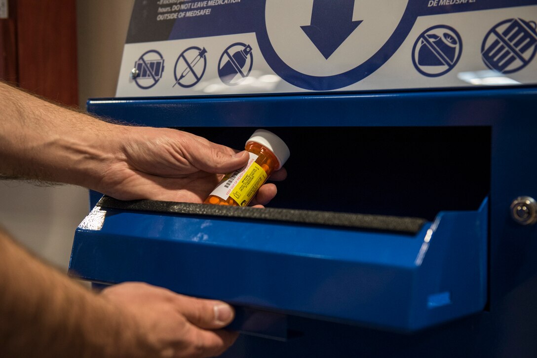 PETERSON AIR FORCE BASE, Colo. – A patient disposes of old medication at the MEDSAFE disposal box located in the lobby of the Peterson Air Force Base Clinic on May 24, 2016. This box and another at the satellite pharmacy located in the base exchange, provide a safe way to keep unsafe substances from falling into the wrong hands. (U.S. Air Force photo by Senior Airman Rose Gudex) 