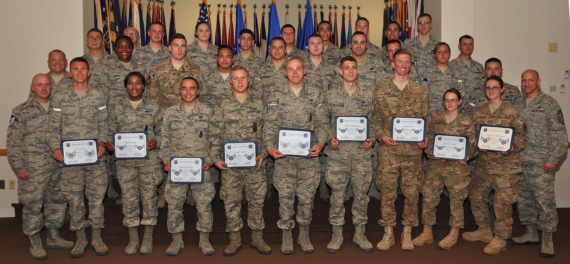 Enlisted F.E. Warren Airmen who promoted in May or put on their new rank on June 1, pose with Col. Matthew Dillow, 90th Missile Wing vice commander, and Chief Master Sgt. Samuel Couch, 90th MW command chief, in the Trail’s End Event Center May 31, 2016. Each month the Mighty Ninety hosts a celebration for enlisted promotees from the base. (U.S. Air Force photo by Senior Airman Brandon Valle)