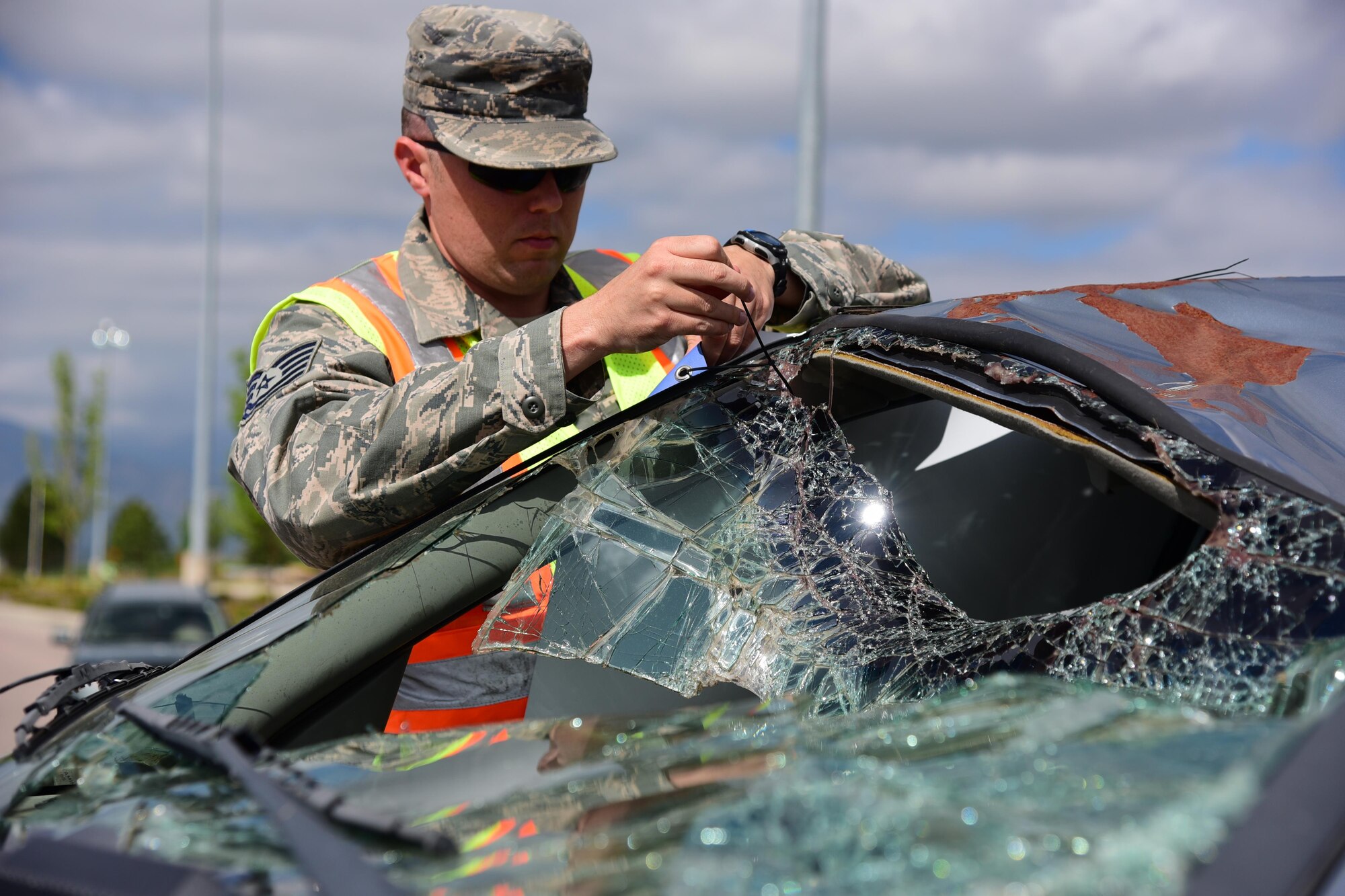 PETERSON AIR FORCE BASE, Colo. – Tech. Sgt. Nicholas Price, 21st Space Wing Safety Office, affixes a sign to the battered husk of a Mercury Mystique displayed just outside the main gate at Peterson Air Force Base, Colo., May 24, 2016. The car, provided by the State of Colorado Traffic Safety awareness program, is part of a statewide campaign to raise awareness by illustrating what a person can survive by simply using their safety belts. (Air Force photo by Staff Sgt. Amber Grimm)