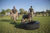 Marines and sailors line up to flip tires across a field at Robertson Barracks, Northern Territory, Australia, May 25, 2016. They had to flip tires if they didn’t win two squad-on-squad ground fighting bouts in order to move on to the next station during the squad competition. The squad-level competition determined which rifle squad or weapons platoon section had the best physical fitness, small-unit leadership, and cohesion within Company C, 1st Battalion, 1st Marine Regiment, Marine Rotational Force – Darwin.