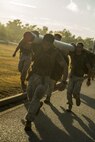 Marines and sailors start a squad competition carrying main packs and logs at Robertson Barracks, Northern Territory, Australia, on May 25, 2016. The squad-level competition determined which rifle squad or weapons platoon section had the best physical fitness, small-unit leadership, and cohesion within Company C, 1st Battalion, 1st Marine Regiment, Marine Rotational Force - Darwin.