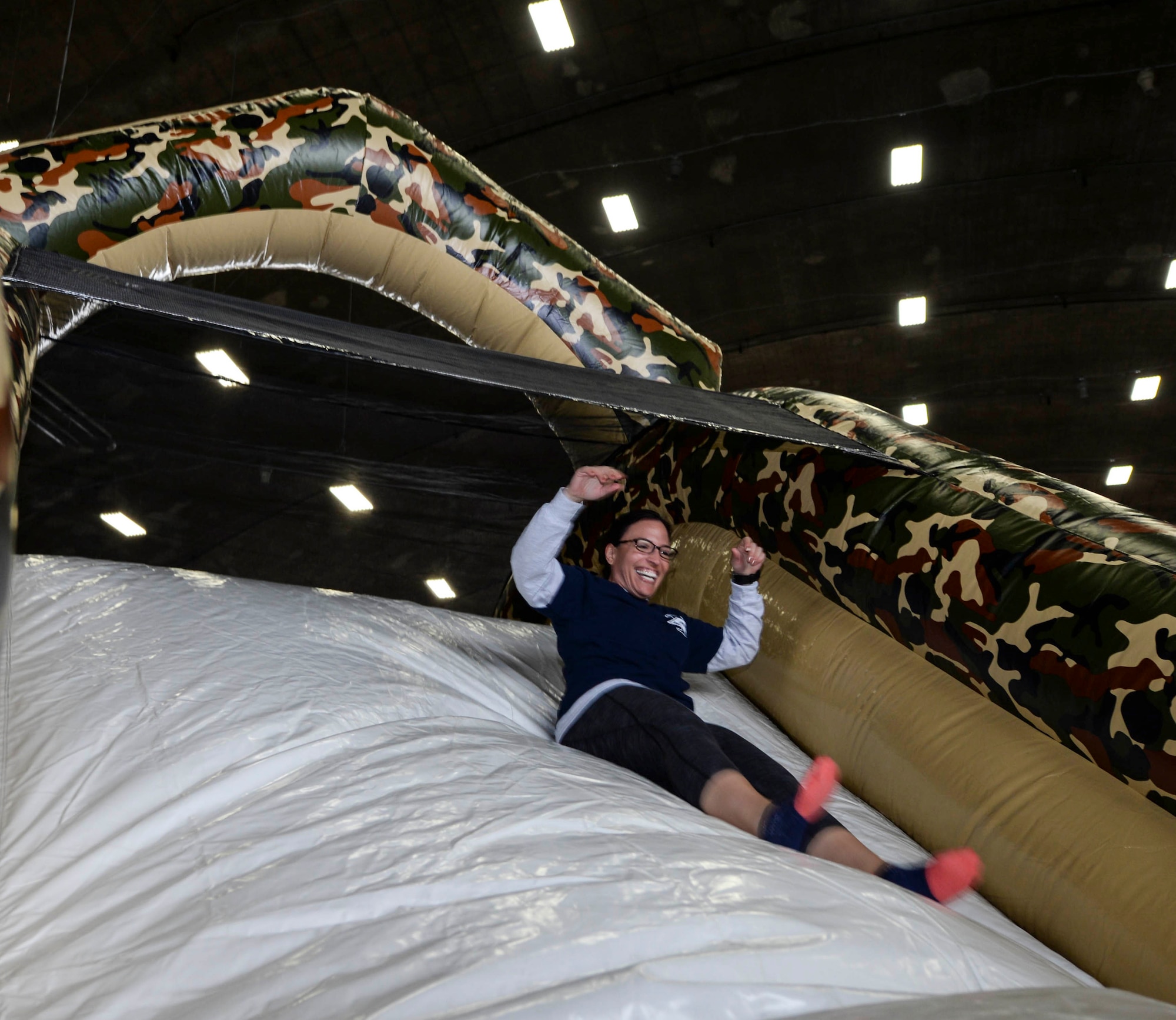 Master Sgt. Kellie Boisse, 28th Logistics Readiness Squadron first sergeant, slides down a party inflatable obstacle during the Battle of the Chevrons at Ellsworth Air Force Base, S.D., May 25, 2016. Six teams, comprised of two first sergeants and two chief master sergeants, competed in team building exercises racing other teams for the fastest time to complete 10 obstacles. (U.S. Air Force photo by Airman 1st Class Sadie Colbert/Released)