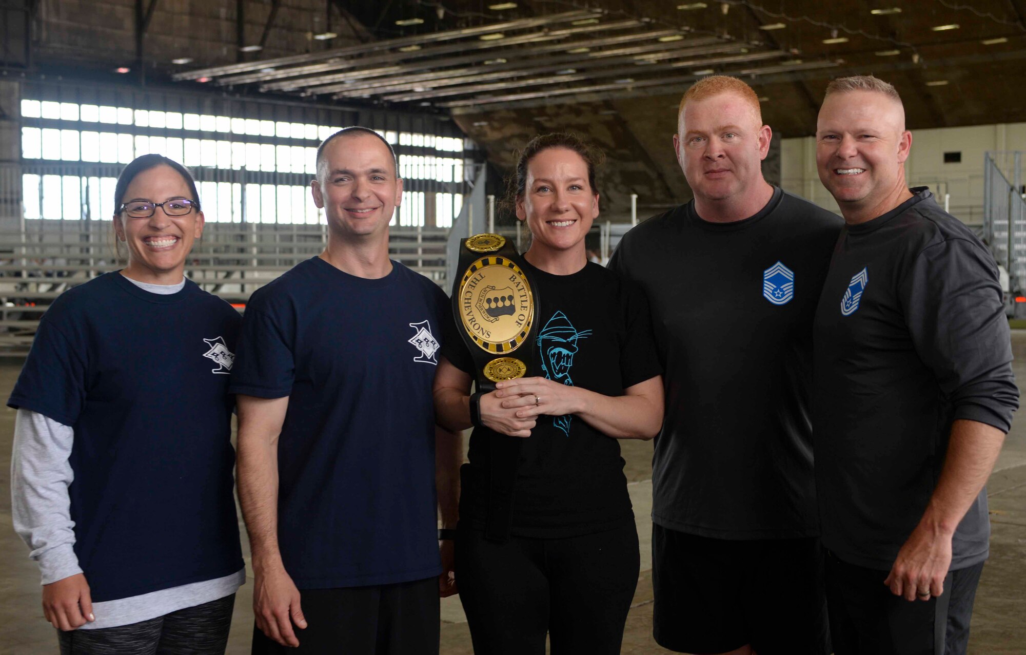 Team five of the Battle of the Chevrons pose with their champion belt at Ellsworth Air Force Base, S.D., May 25, 2016. The competition is a team building exercise that included 10 stations to test Airmen mentally or physically. (U.S. Air Force photo by Airman 1st Class Sadie Colbert/Released)