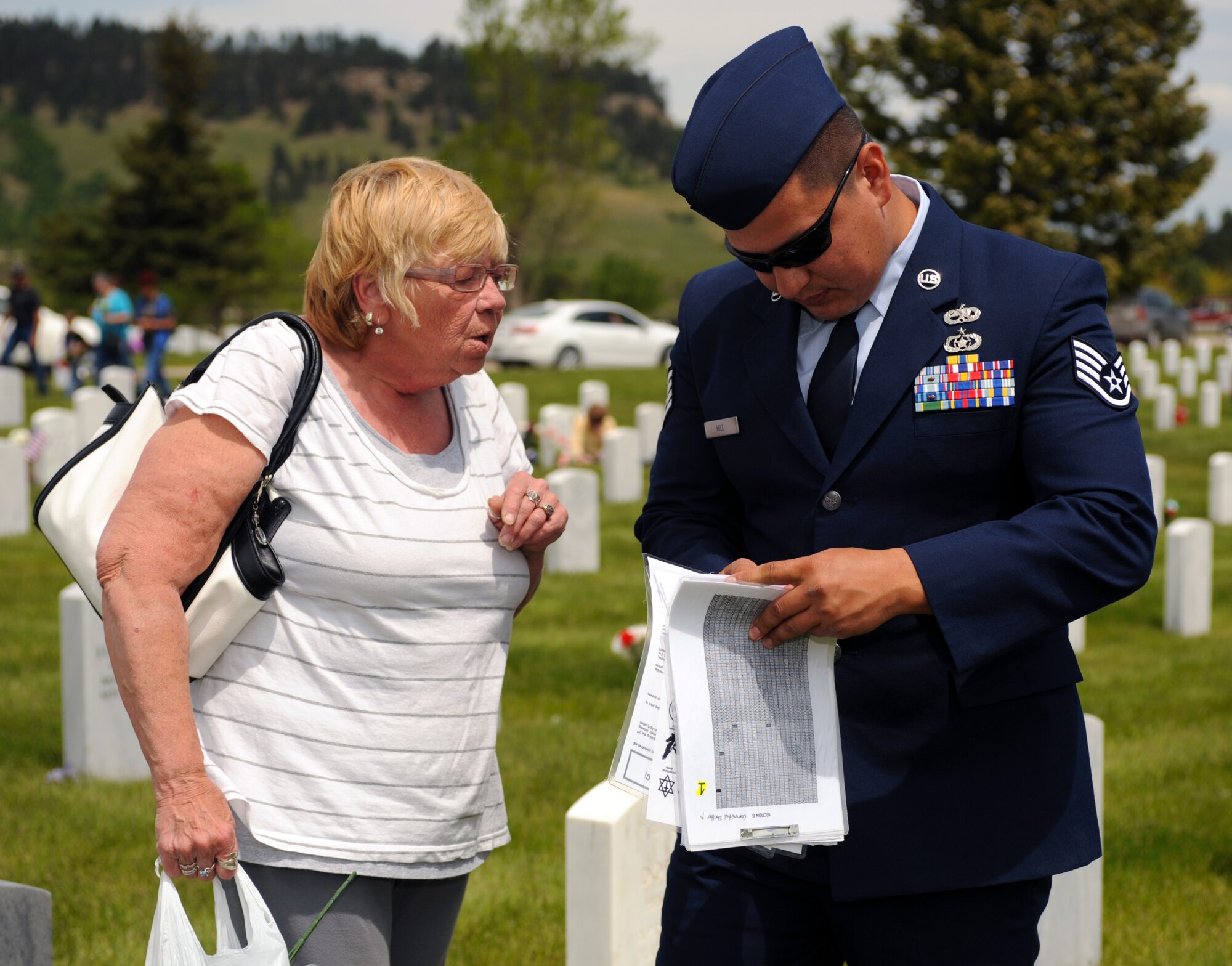 Staff Sgt. Kenneth Hill, 28th Bomb Wing occupational safety technician, helps a family member locate a gravesite at the Black Hills National Cemetery in Sturgis, S.D., May 30, 2016. On Memorial Day, family members from all over arrive at cemeteries across the country to pay their respect for loved ones they have lost. (U.S. Air Force photo by Airman 1st Class Denise M. Nevins/Released)