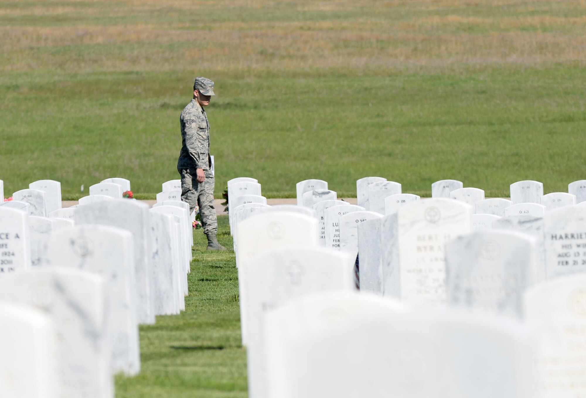 Airman 1st Class Nathanial Nagel, 28th Maintenance Group dedicated analyst, searches for a tombstone for a family at the Black Hills National Cemetery, Sturgis, S.D., May 28, 2016. More than 190 Airmen from the base volunteered at the cemetery over Memorial Day weekend, providing escorts to families visiting their fallen servicemembers. (U.S. Air Force photo by Airman 1st Class Sadie Colbert/Released)