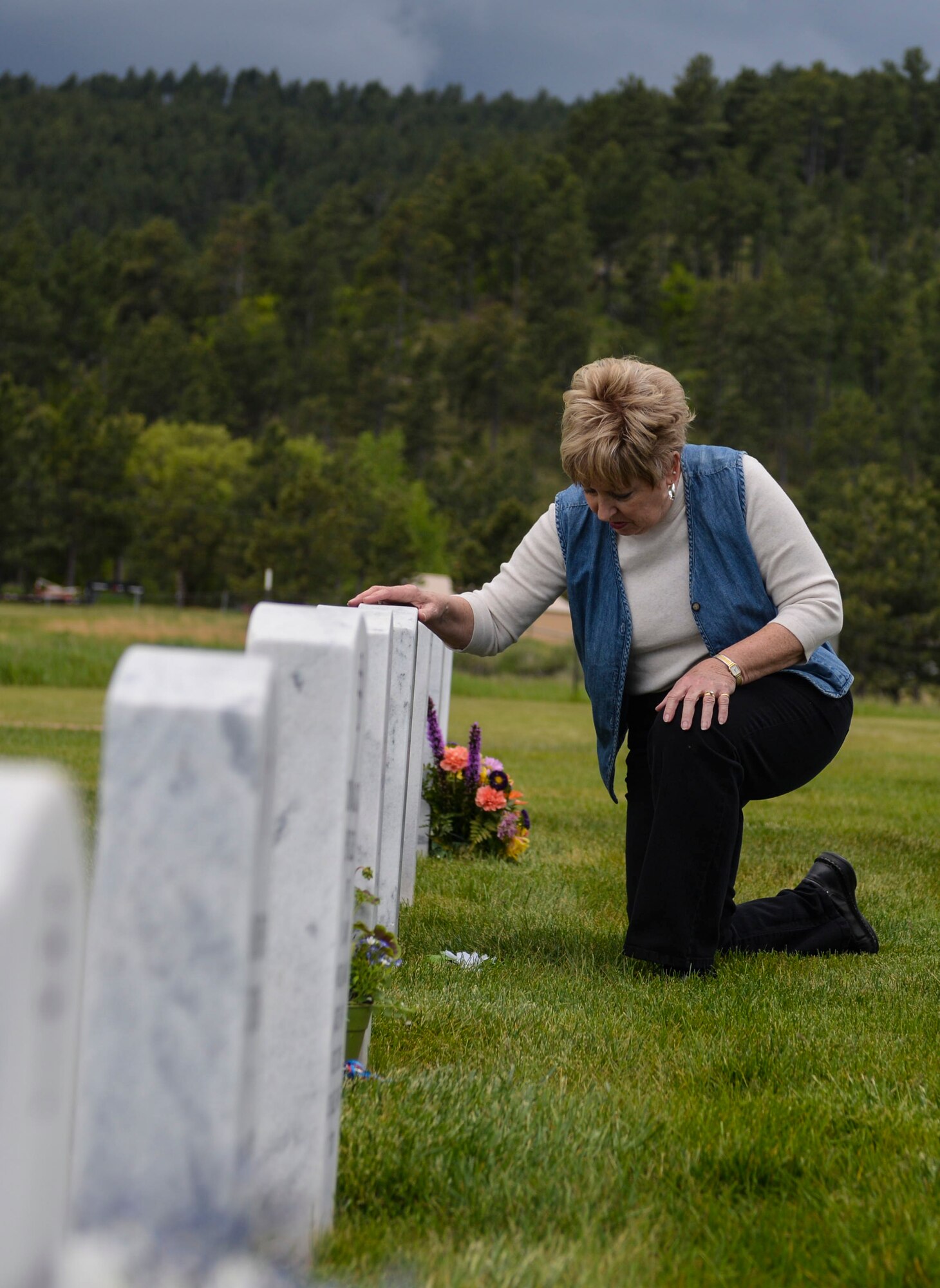 Karen Bentz, local of Nemo, S.D., visits a tombstone at the Black Hills National Cemetery in Sturgis, S.D., May 28, 2016. The Black Hills Cemetery was established in 1948 and is situated on 106 acres of land to accommodate casketed and cremated remains. To contact the cemetery and locate a gravesite, call (800) 535-1117. (U.S. Air Force photo by Airman 1st Class Sadie Colbert/Released)