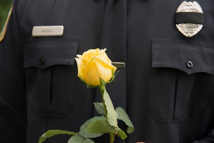A Charleston police officer holds a single yellow rose in remembrance of his fellow co-worker, Detective Sergeant Christopher Kelley.  A yellow rose is often presented to honor and remember a friendship.  In honor of Police Week, the 628th SFS collaborated with multiple base agencies to conduct various events to remember and celebrate their fallen brothers and sisters in law enforcement. (U.S. Air Force Photo/Airman 1st Class Haleigh Laverty)