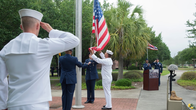 Joint Base Charleston Color Guard members lower the flag for Retreat during the National Police Week ceremony May 20, 2016, at the base flag pole on Joint Base Charleston – Air Base, S.C.  In honor of Police Week, the 628th Security Forces Squadron collaborated with multiple base agencies to conduct various events to remember and celebrate their fallen brothers and sisters in law enforcement. (U.S. Air Force Photo/Airman 1st Class Haleigh Laverty)