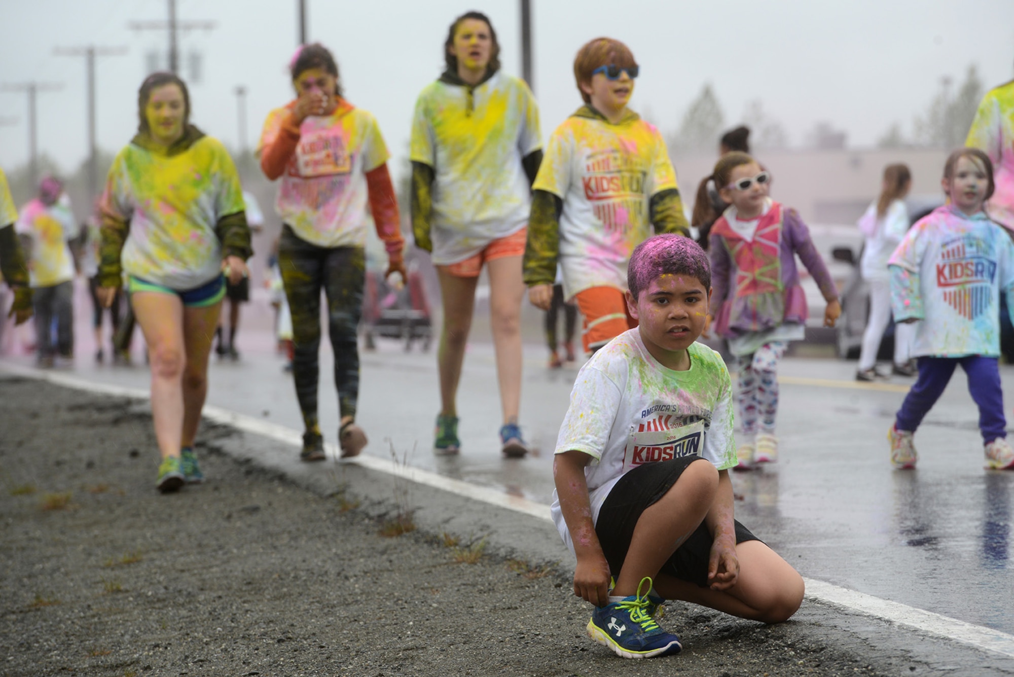 A child takes a break during the America’s Armed Forces Color Run at Joint Base Elmendorf-Richardson, Alaska, May 21, 2016. The Alaska Military Youth Academy, JBER Life, USO, and volunteers provided water, food, photo opportunities, and dye at multiple stations along the run. (U.S. Air Force photo by Airman 1st Class Christopher R. Morales)