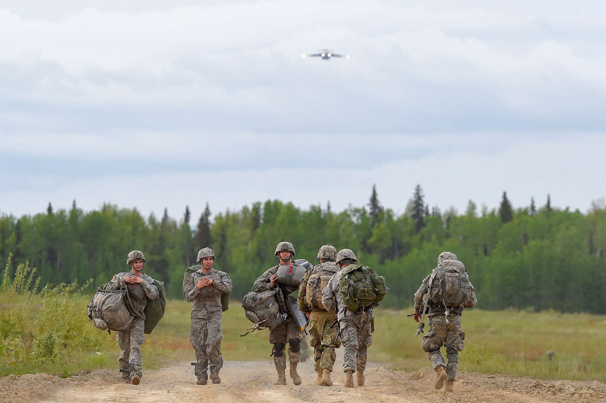 U.S. Army paratroopers assigned to the 1st Battalion, 501st Parachute Infantry Regiment, 4th Infantry Brigade Combat Team (Airborne), 25th Infantry Division, proceed to rally and collection points after conducting joint airborne and air transportability training (JAATT) at Malemute drop zone, Joint Base Elmendorf-Richardson, Alaska, May 19, 2016. JAATT familiarizes units with establishing drop zones and airfields, as well as proper communication with aircraft supporting resupply missions. The Soldiers of 4/25 IBCT belong to the only American airborne brigade in the Pacific and are trained to execute airborne maneuvers in extreme cold weather/high altitude environments in support of combat, partnership and disaster relief operations. (U.S. Air Force photo by Alejandro Pena)
