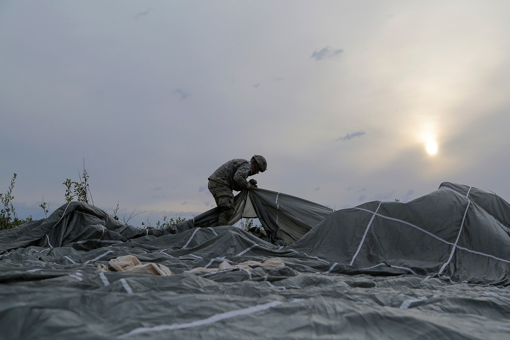 U.S. Army Spc. Donald Shingleton, assigned to the 1st Battalion, 501st Parachute Infantry Regiment, 4th Infantry Brigade Combat Team (Airborne), 25th Infantry Division, recovers his parachute during joint airborne and air transportability training (JAATT) at Joint Base Elmendorf-Richardson, Alaska, May 19, 2016. JAATT familiarizes units with establishing drop zones and airfields, as well as proper communication with aircraft supporting resupply missions. The Soldiers of 4/25 IBCT belong to the only American airborne brigade in the Pacific and are trained to execute airborne maneuvers in extreme cold weather/high altitude environments in support of combat, partnership and disaster relief operations. (U.S. Air Force photo by Alejandro Pena)