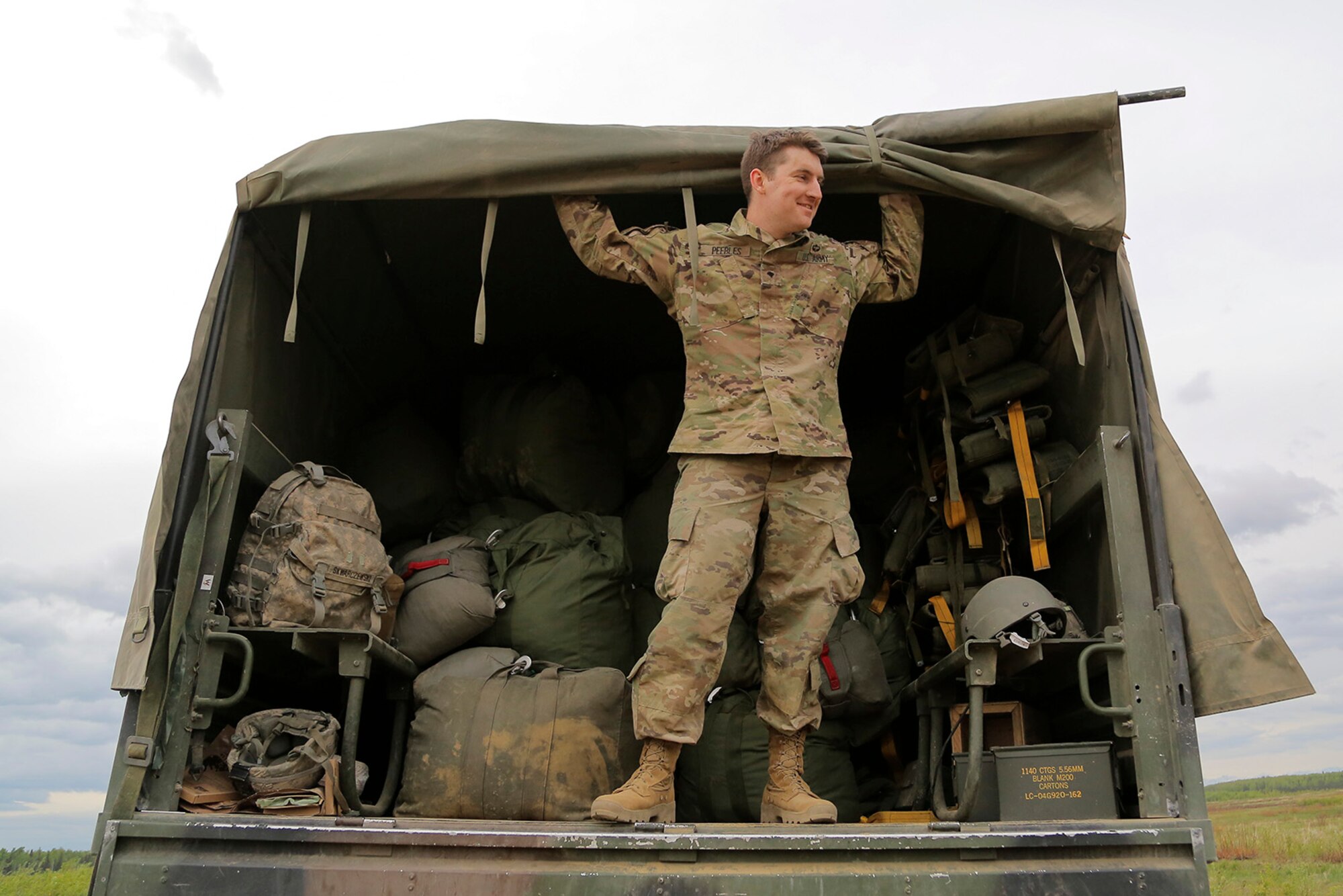 U.S. Army Spc. Donald Peebles, assigned to the 1st Battalion, 501st Parachute Infantry Regiment, 4th Infantry Brigade Combat Team (Airborne), 25th Infantry Division, waits to collect used parachutes after conducting joint airborne and air transportability training (JAATT) at Joint Base Elmendorf-Richardson, Alaska, May 19, 2016. JAATT familiarizes units with establishing drop zones and airfields, as well as proper communication with aircraft supporting resupply missions. The Soldiers of 4/25 IBCT belong to the only American airborne brigade in the Pacific and are trained to execute airborne maneuvers in extreme cold weather/high altitude environments in support of combat, partnership and disaster relief operations. (U.S. Air Force photo by Alejandro Pena)