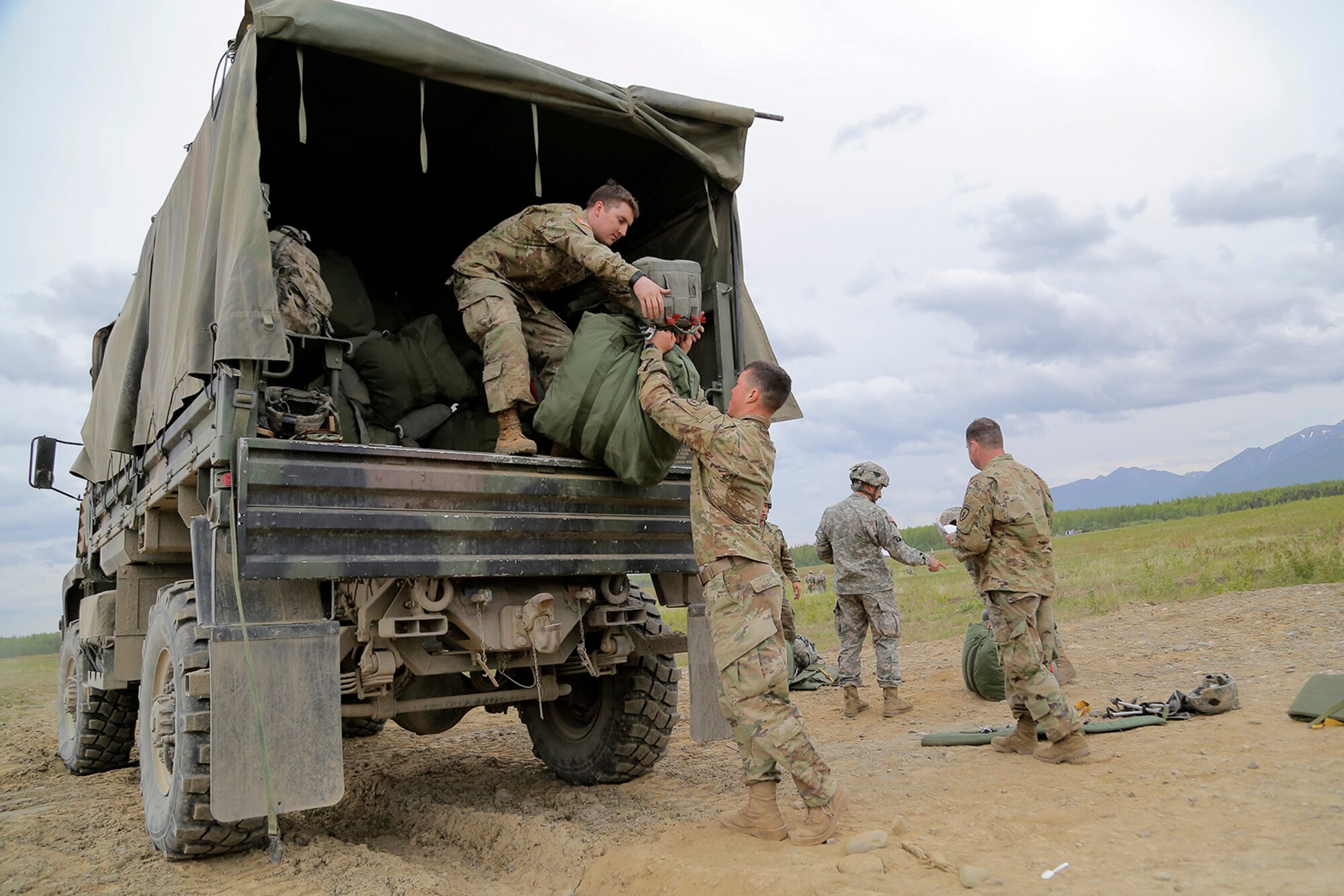 U.S. Army paratroopers assigned to the 1st Battalion, 501st Parachute Infantry Regiment, 4th Infantry Brigade Combat Team (Airborne), 25th Infantry Division, collect used parachutes at a collection point after conducting joint airborne and air transportability training (JAATT) at Joint Base Elmendorf-Richardson, Alaska, May 19, 2016. JAATT familiarizes units with establishing drop zones and airfields, as well as proper communication with aircraft supporting resupply missions. The Soldiers of 4/25 IBCT belong to the only American airborne brigade in the Pacific and are trained to execute airborne maneuvers in extreme cold weather/high altitude environments in support of combat, partnership and disaster relief operations. (U.S. Air Force photo by Alejandro Pena)
