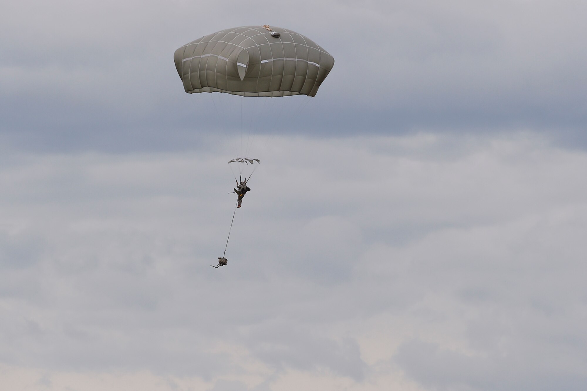 A U.S. Army paratrooper assigned to the 1st Battalion, 501st Parachute Infantry Regiment, 4th Infantry Brigade Combat Team (Airborne), 25th Infantry Division, descends over Malemute drop zone during joint airborne and air transportability training (JAATT) at Joint Base Elmendorf-Richardson, Alaska, May 19, 2016. JAATT familiarizes units with establishing drop zones and airfields, as well as proper communication with aircraft supporting resupply missions. The Soldiers of 4/25 IBCT belong to the only American airborne brigade in the Pacific and are trained to execute airborne maneuvers in extreme cold weather/high altitude environments in support of combat, partnership and disaster relief operations. (U.S. Air Force photo by Alejandro Pena)