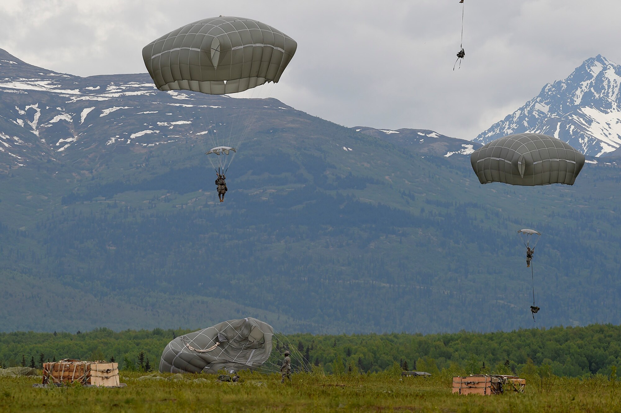U.S. Army paratroopers assigned to the 1st Battalion, 501st Parachute Infantry Regiment, 4th Infantry Brigade Combat Team (Airborne), 25th Infantry Division, descend onto Malemute drop zone during joint airborne and air transportability training (JAATT) at Joint Base Elmendorf-Richardson, Alaska, May 19, 2016. JAATT familiarizes units with establishing drop zones and airfields, as well as proper communication with aircraft supporting resupply missions. The Soldiers of 4/25 IBCT belong to the only American airborne brigade in the Pacific and are trained to execute airborne maneuvers in extreme cold weather/high altitude environments in support of combat, partnership and disaster relief operations. (U.S. Air Force photo by Alejandro Pena)