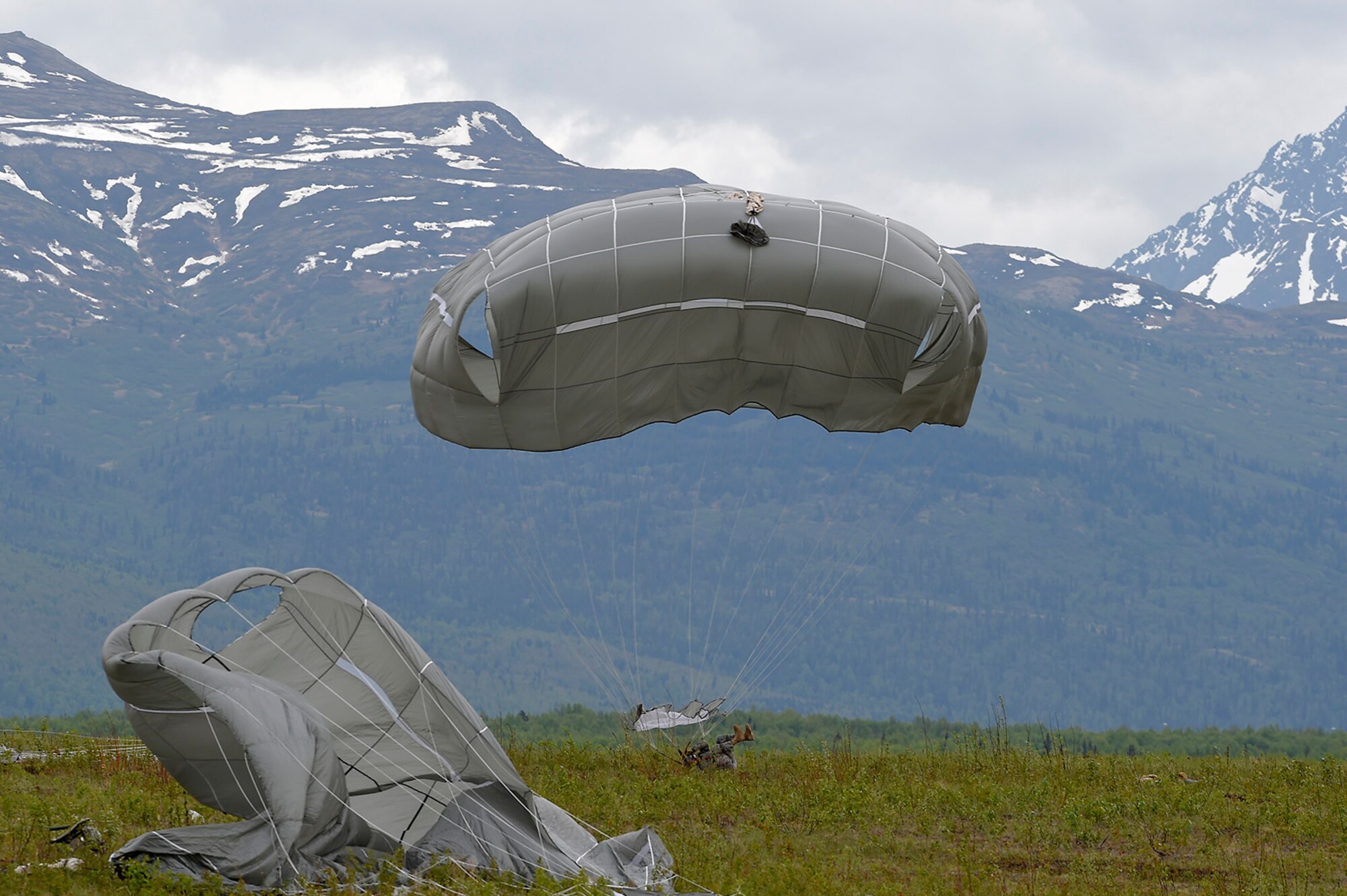 A U.S. Army paratrooper assigned to the 1st Battalion, 501st Parachute Infantry Regiment, 4th Infantry Brigade Combat Team (Airborne), 25th Infantry Division, land onto Malemute drop zone during joint airborne and air transportability training (JAATT) at Joint Base Elmendorf-Richardson, Alaska, May 19, 2016. JAATT familiarizes units with establishing drop zones and airfields, as well as proper communication with aircraft supporting resupply missions. The Soldiers of 4/25 IBCT belong to the only American airborne brigade in the Pacific and are trained to execute airborne maneuvers in extreme cold weather/high altitude environments in support of combat, partnership and disaster relief operations. (U.S. Air Force photo by Alejandro Pena)