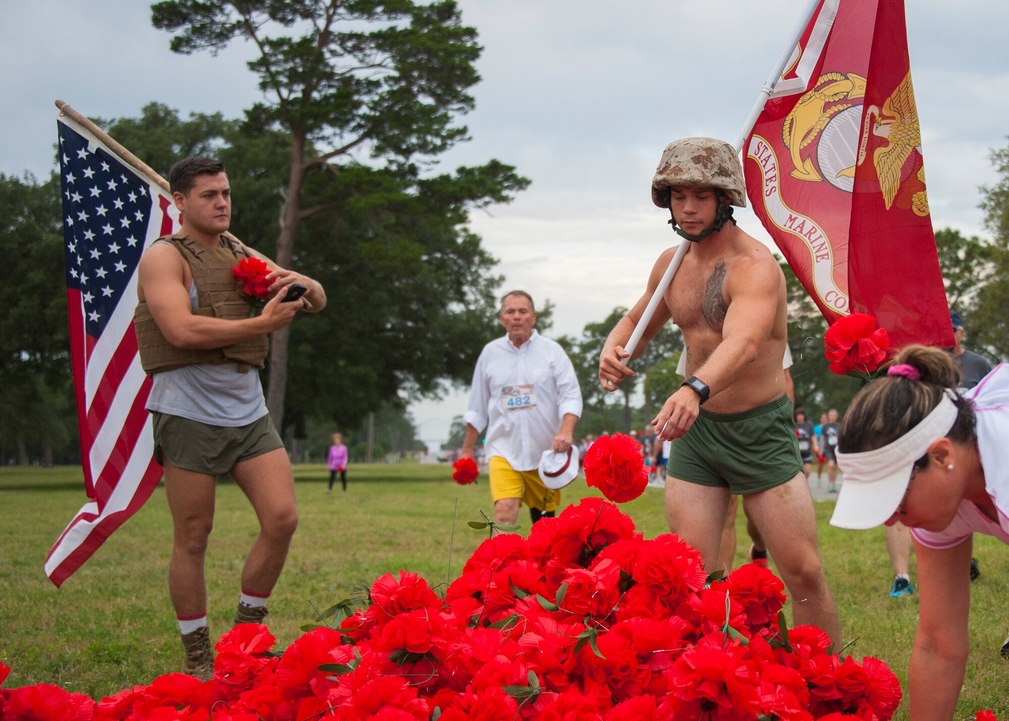 Run participants drop red flowers during the 31st annual Gate to Gate Run May 28 at Eglin Air Force Base, Fla. More than 1,050 runners and walkers partook in the Memorial Day Race and paid respects to the country’s fallen with red flowers at the All Wars Memorial as they ran by. (U.S. Air Force photo/Ilka Cole)