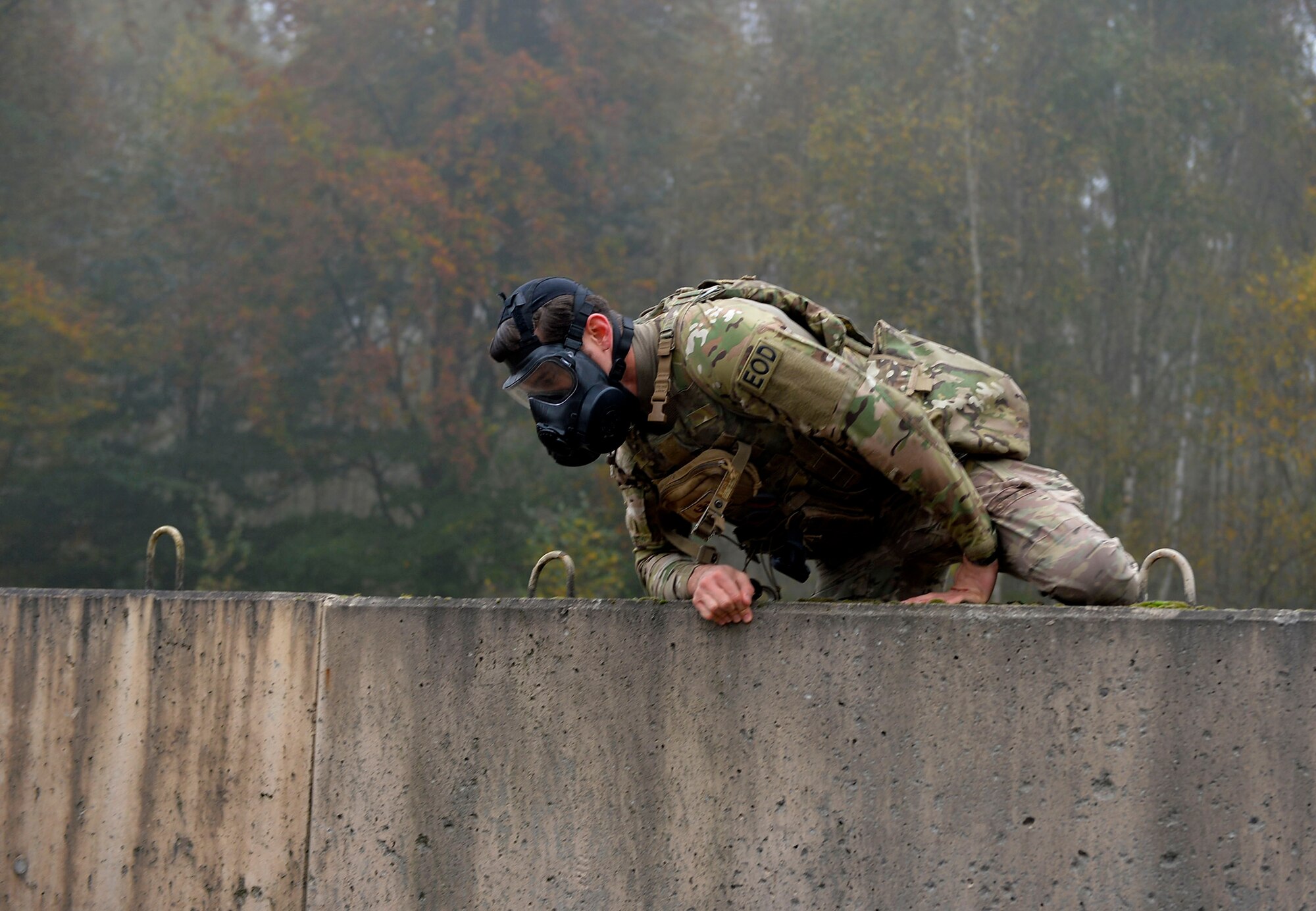 An explosive ordnance disposal Airman with the 786th Civil Engineer Squadron climbs over a wall during a special ruck and run event in support of the Combined Federal Campaign. The 786th CES’s EOD flight conducts ruck marches at the last Friday of every month. (U.S. Air Force photo by Airman 1st Class Joshua Magbanua)