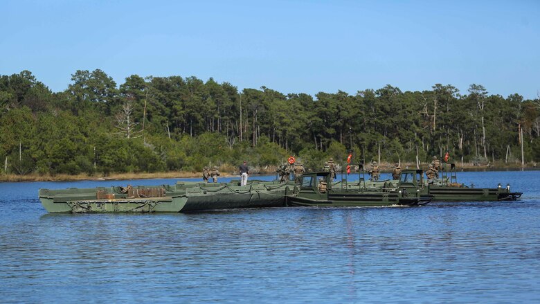 Marines with 1st Platoon, Bridge Company, 8th Electronic Support Battalion, link pieces of an improvised ribbon raft together to create a ramp for Marines from 3rd Battalion, 8th Marines to cross the waterway during the Marine Corps Combat Readiness Evaluation at Camp Lejeune, N.C., Oct. 26, 2016. The raft will be used to load, transport and deliver Marines and their vehicles during the following phase of the MCCRE. 