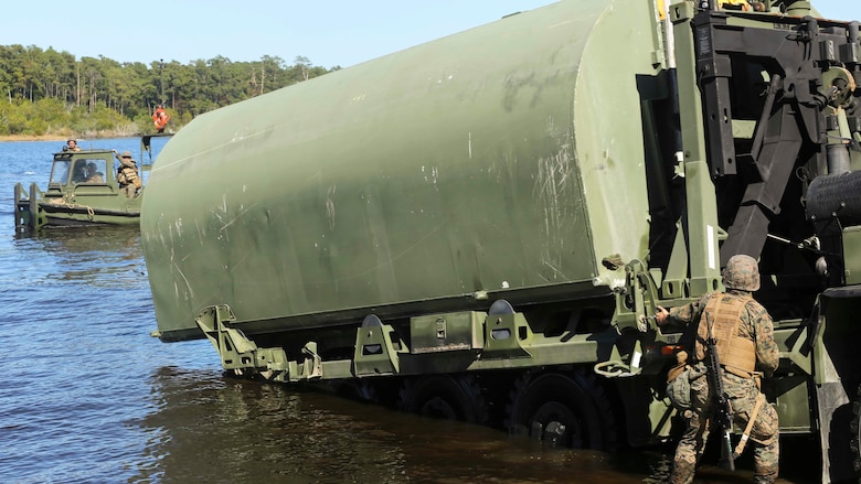 Lance Cpl. Jordan Miller, with 1st Platoon, Bridge Company, 8th Electronic Support Battalion, calls commands while releasing the lever that keeps part of improvised ribbon raft attached during the the Marine Corps Combat Readiness Evaluation  at Camp Lejeune, N.C., Oct. 26, 2016. The MCCRE is a training exercise where various units are evaluated in the performance of all tasks, as they pertain to combat readiness.
