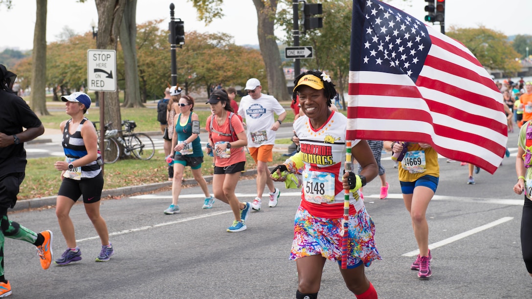 A runner carries the American flag past the 10-mile marker as part of the 41st Marine Corps Marathon, Oct. 30, 2016. The MCM is a 26.2-mile course that runs through Washington, D.C. and Northern Virginia. The Marine Corps Marathon is also known as “The People’s Marathon.”