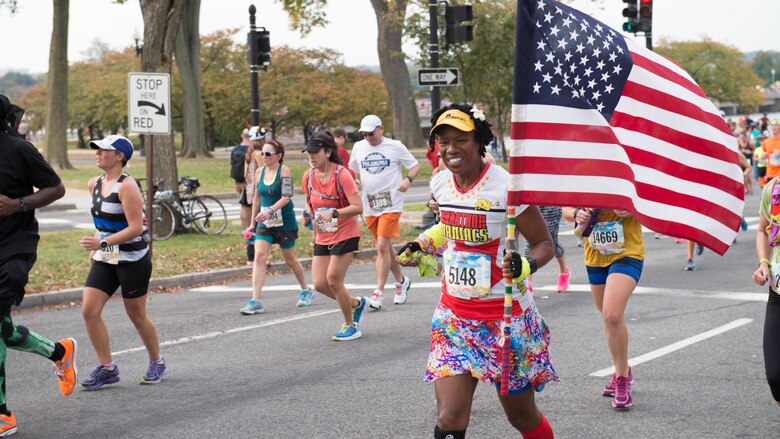 A runner carries the American flag past the 10-mile marker as part of the 41st Marine Corps Marathon, Oct. 30, 2016. The MCM is a 26.2-mile course that runs through Washington, D.C. and Northern Virginia. The Marine Corps Marathon is also known as “The People’s Marathon.”