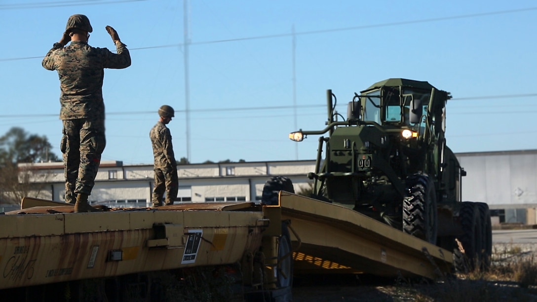 Marines guide a tractor up the railhead ramp onto a railcar during railhead operation training at Camp Lejeune, N.C., Oct. 26, 2016. 2nd Transportation Support Battalion participated in the training to get Marines certified to conduct railhead operations in the future. These Marines are with 2nd TSB. 