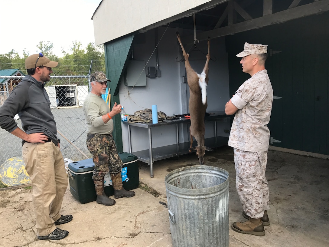 Jim Cook, Retired Marine, Range & Training Area Management civilian and avid hunter of deer and small game utilized the skinning shed at the game check station. Jim shared the story of his successful crossbow hunt with Col. Murray, Commanding Officer, MCINCR-MCBQ and Brad Watkin, Wildlife Biologist, NREA.