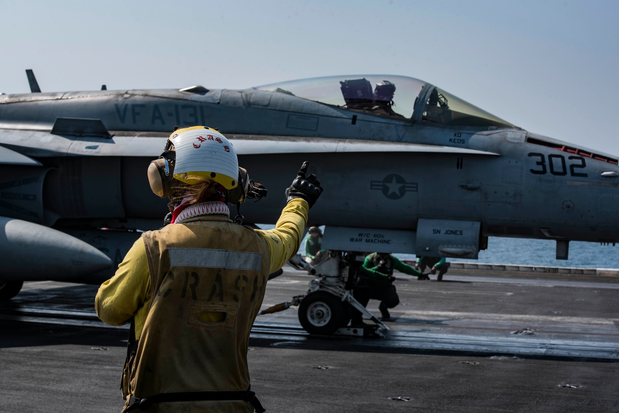 Petty Officer 3rd Class Gabrielle Embry signals to an F/A-18F Super Hornet, assigned to Strike Fighter Squadron (VFA) 131, on the flight deck of the aircraft carrier USS Dwight D. Eisenhower (CVN 69) (Ike). Embry serves as an aviation boatswain’s mate (handling) aboard Ike. Ike and its carrier strike group are deployed in support of Operation Inherent Resolve, maritime security operations and theater security cooperation efforts in the U.S. 5th Fleet area of operations. (U.S. Navy photo/Petty Officer 3rd Class Nathan T. Beard)