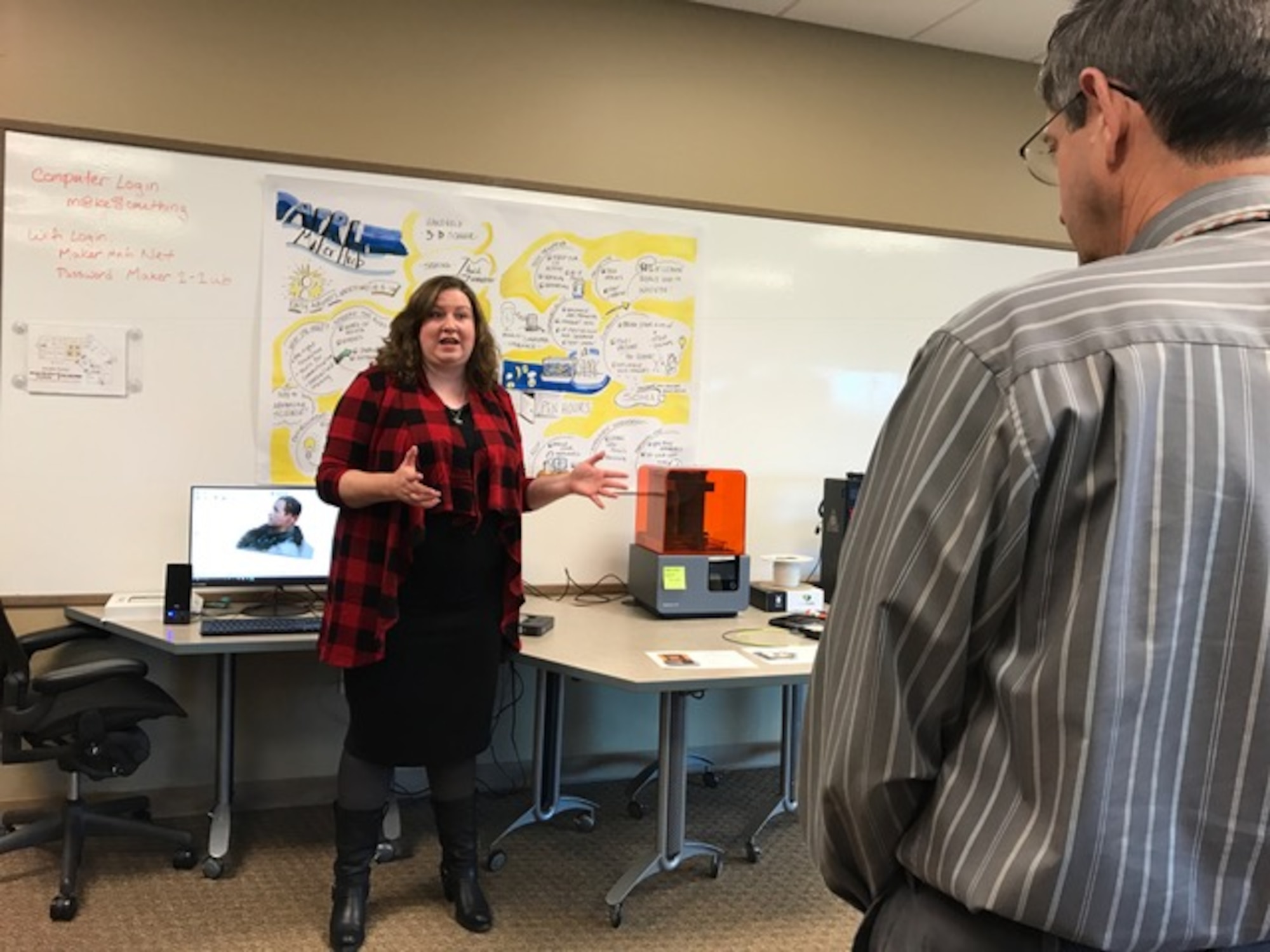 AFRL Maker Hub director Dr. Emily Ferhman Cory, describes to attendees how the desktop 3-D printing machine works at the AFRL Maker Hub grand opening held on October 27, 2016. (U.S. photo/Stacey Geiger)

