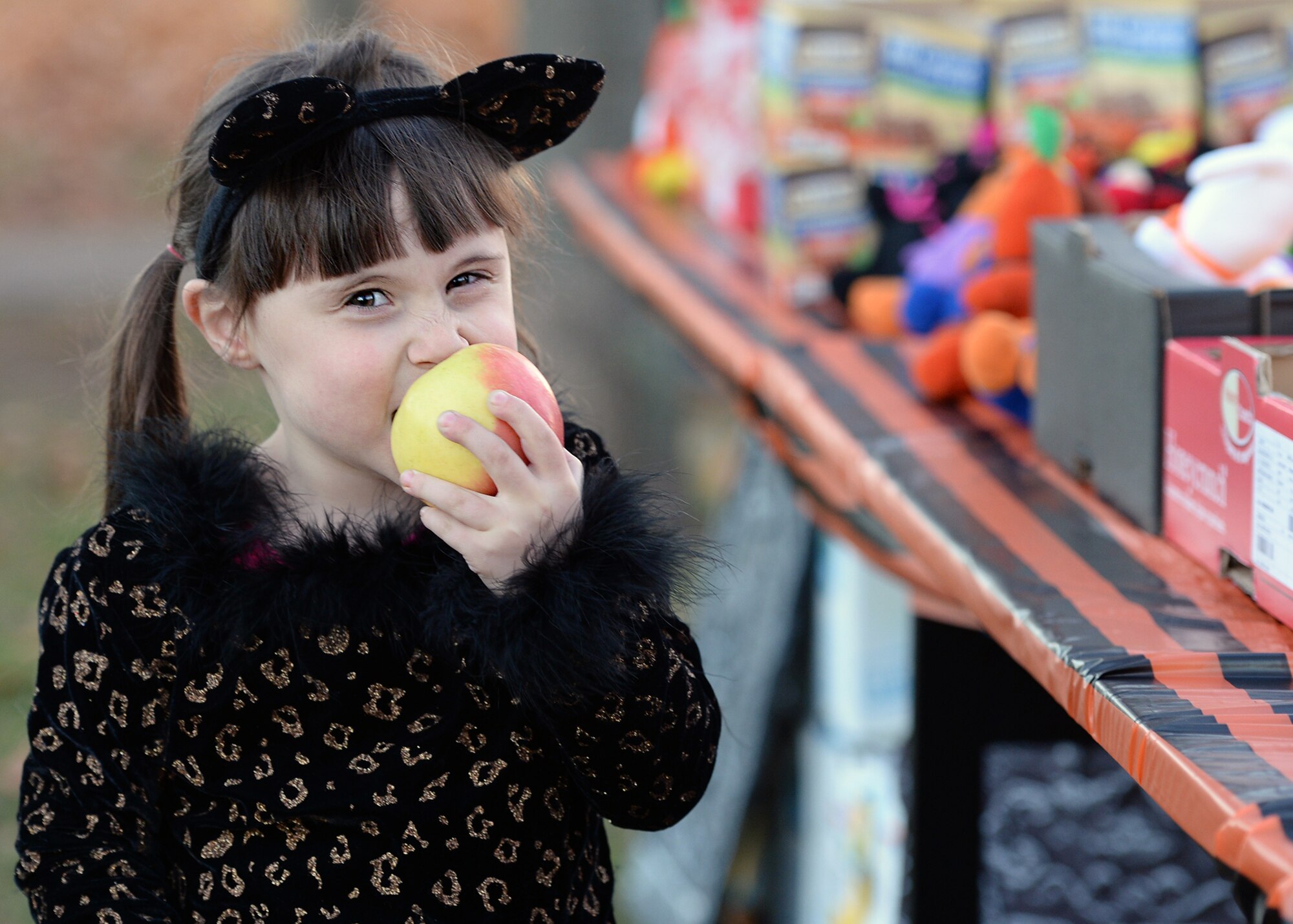 Geri Wesley, a Team Ramstein child, eats an apple during a Trunk or Treat event on Ramstein Air Base, Germany, Oct. 31, 2016. The event featured a healthy snack station, that served fruits and healthier snack alternatives to candy, for kids who had allergies or other dietary restrictions. (U.S. Air Force photo by Senior Airman Jimmie D. Pike)