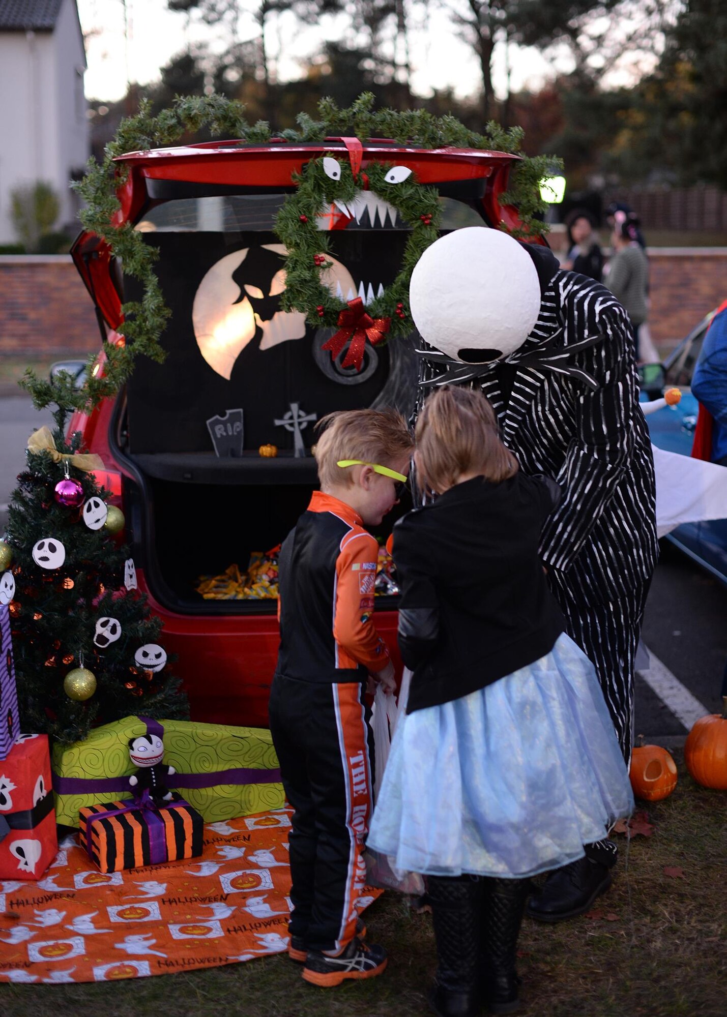 Staff Sgt. Brian Field, 86th Maintenance Squadron test measurement and diagnostic equipment technician, dressed as Jack Skellington hands out candy at Ramstein Air Base, Germany, Oct. 31, 2016. Volunteers dedicated their time to set-up, decorate, and handout candy to families for the annual Trunk or Treat event. (U.S. Air Force photo by Senior Airman Jimmie D. Pike)