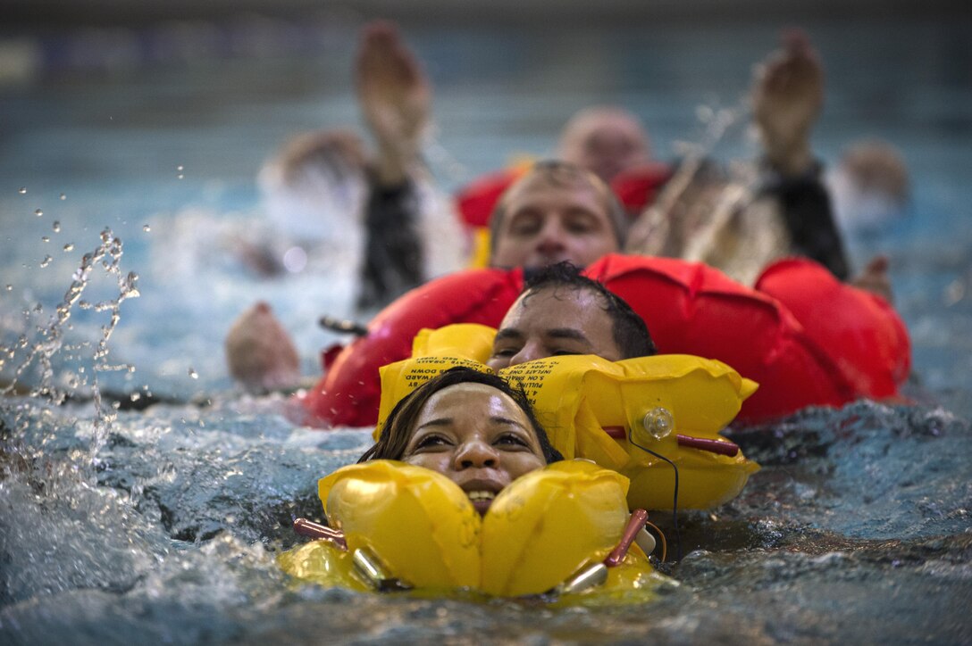 Staff Sgt. Jeannette Esson, 89th Airlift Wing flight attendant, swims in tandem with other aircrew members as a linked group during Water Survival Training at Prince George’s Community College’s Robert I. Bickford Natatorium in Largo, Md., Oct. 27, 2016. Swimming linked together saves energy when swimming for long periods in open water, which could be vital in a real-world water survival scenario. (U.S. Air Force photo by Senior Airman Philip Bryant)