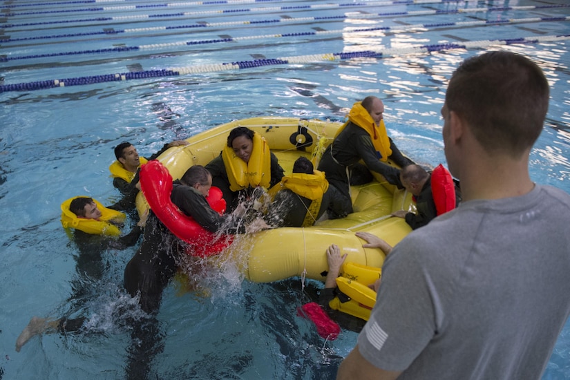 Flight crew members from the National Capital Region pull each other into a life raft during Water Survival Training with 89th Operations Support Squadron survival, evasion, resistance and escape specialists at Prince George’s Community College’s Robert I. Bickford Natatorium in Largo, Md., Oct. 27, 2016. The Water Survival Training equips these Airmen with the knowledge and confidence needed to survive in an open ocean environment using the equipment onboard their aircraft. (U.S. Air Force photo by Senior Airman Philip Bryant)