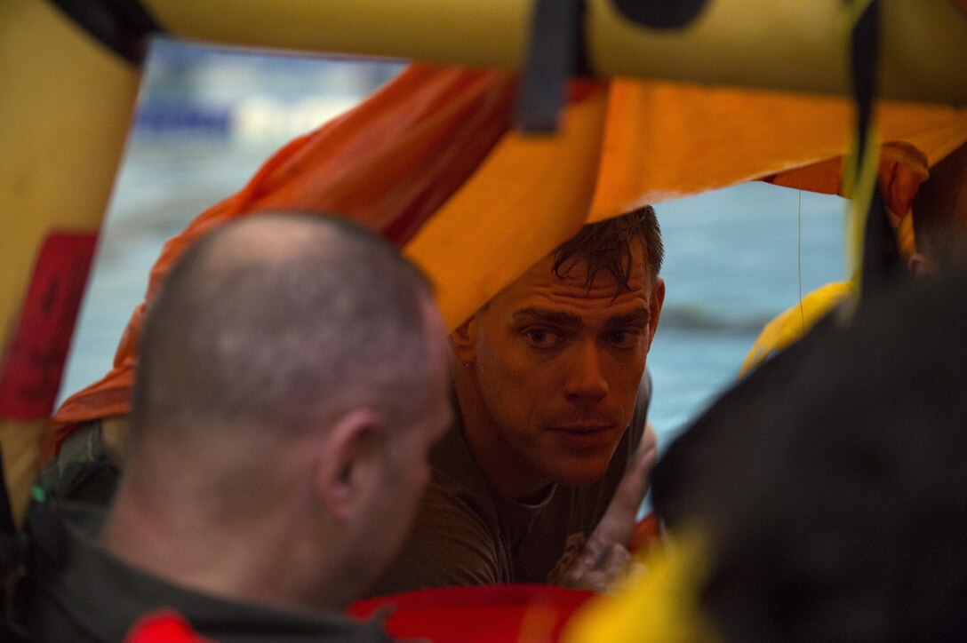 Tech. Sgt. Jason Davis, 89th Operations Support Squadron survival, evasion, resistance and escape specialist, teaches aircrew members Water Survival Training while inside a life raft at Prince George’s Community College’s Robert I. Bickford Natatorium in Largo, Md., Oct. 27, 2016. Davis, who is also a flight chief, has been a SERE specialist for more than 13 years and now teaches SERE techniques and methods to aircrew members across the National Capital Region. (U.S. Air Force photo by Senior Airman Philip Bryant)