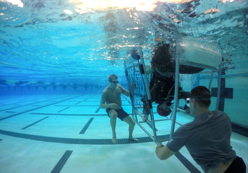 Lt. Col. Dave Fink, 1st Helicopter Squadron pilot, sits upside down during Helicopter Emergency Egress Device Training at Prince George’s Community College’s Robert I. Bickford Natatorium in Largo, Md., Oct. 28, 2016. The training, specific to helicopter aircrews, teaches the proper way to evacuate a helicopter if it goes down over a body of water. (U.S. Air Force photo by Senior Airman Philip Bryant)