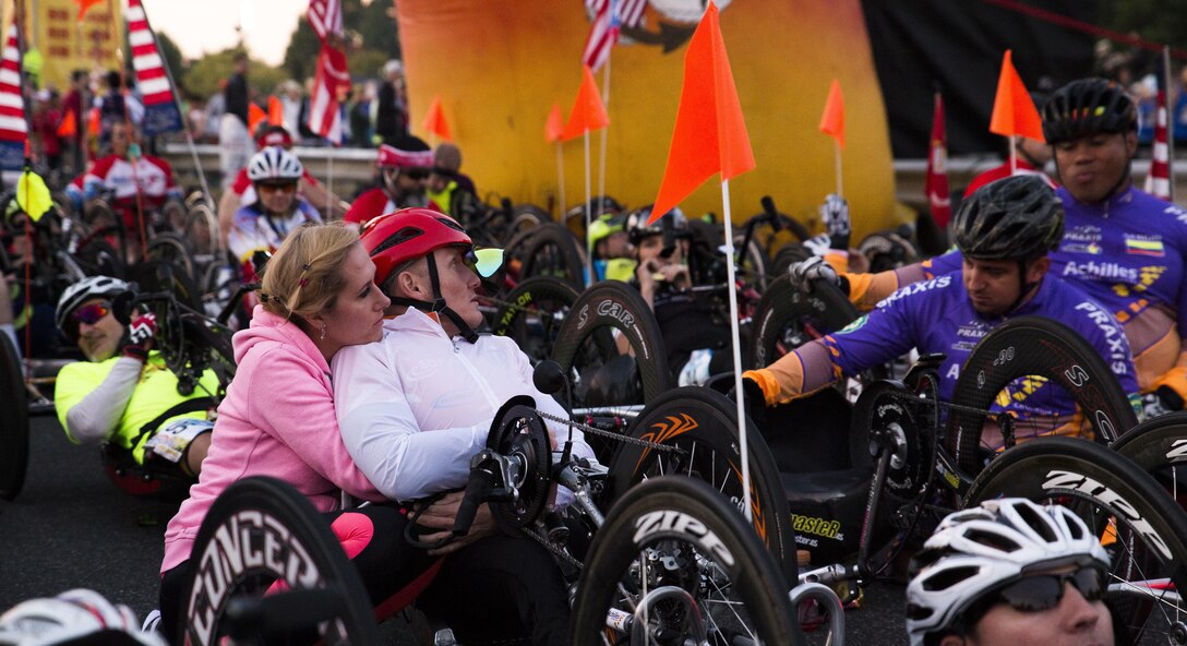 Hand cyclist Arkadiusz Skrzypinski gets an embrace before the start of the 41st Marine Corps Marathon in Washington, D.C., Oct. 30, 2016. More than 30,000 participants, volunteers, and spectators flooded the city in support of the 26.2 mile race. Marine Corps photo by Lance Cpl. Dana Beesley