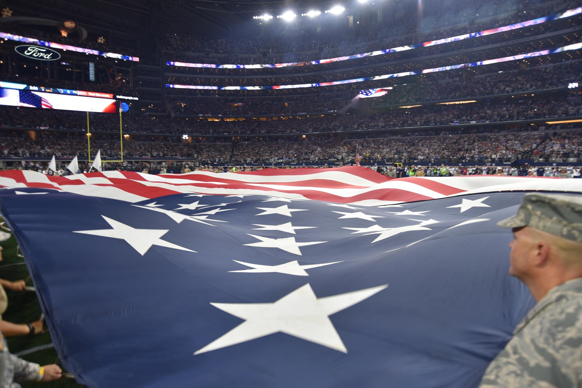 Nearly 70 Airmen, Sailors, Soldiers and Marines from Naval Air Station Fort Worth Joint Reserve Base, Texas, present a 40-yard flag during pre-game activities in front of thousands of Dallas Cowboy and Philadelphia Eagle fans Oct. 30, 2016, at AT&T Stadium. The Cowboys ousted the Eagles in a nail-biting overtime to win, 29-23, taking their spot atop the National Football Conference East. (U.S. Air Force photo by Julie Briden-Garcia)
