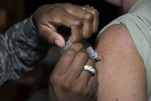 Tech. Sgt. Surinia Thurman, 436th Aerospace Medicine Squadron independent duty medical technician, administers a flu vaccine to Master Sgt. Melinda Santiago, 436th Aerial Port Squadron Air Transportation Standardization and Evaluations Program manager, during a 436th Medical Group point of distribution exercise Oct. 25, 2016, at the Landings on Dover Air Force Base, Del. By administering flu vaccines during the POD exercise, the 436th MDG was able to meet both vaccination and training requirements. (U.S. Air Force photo by Senior Airman Aaron J. Jenne) 