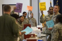 Airmen of the 436th and 166th Medical Groups hold up numbered signs signifying they are available to accept a patient during a 436th MDG point of distribution exercise Oct. 25, 2016, at the Landings on Dover Air Force Base, Del. Twenty-one medical Airmen administered 1,205 vaccines during the 13-hour event. (U.S. Air Force photo by Senior Airman Aaron J. Jenne)
