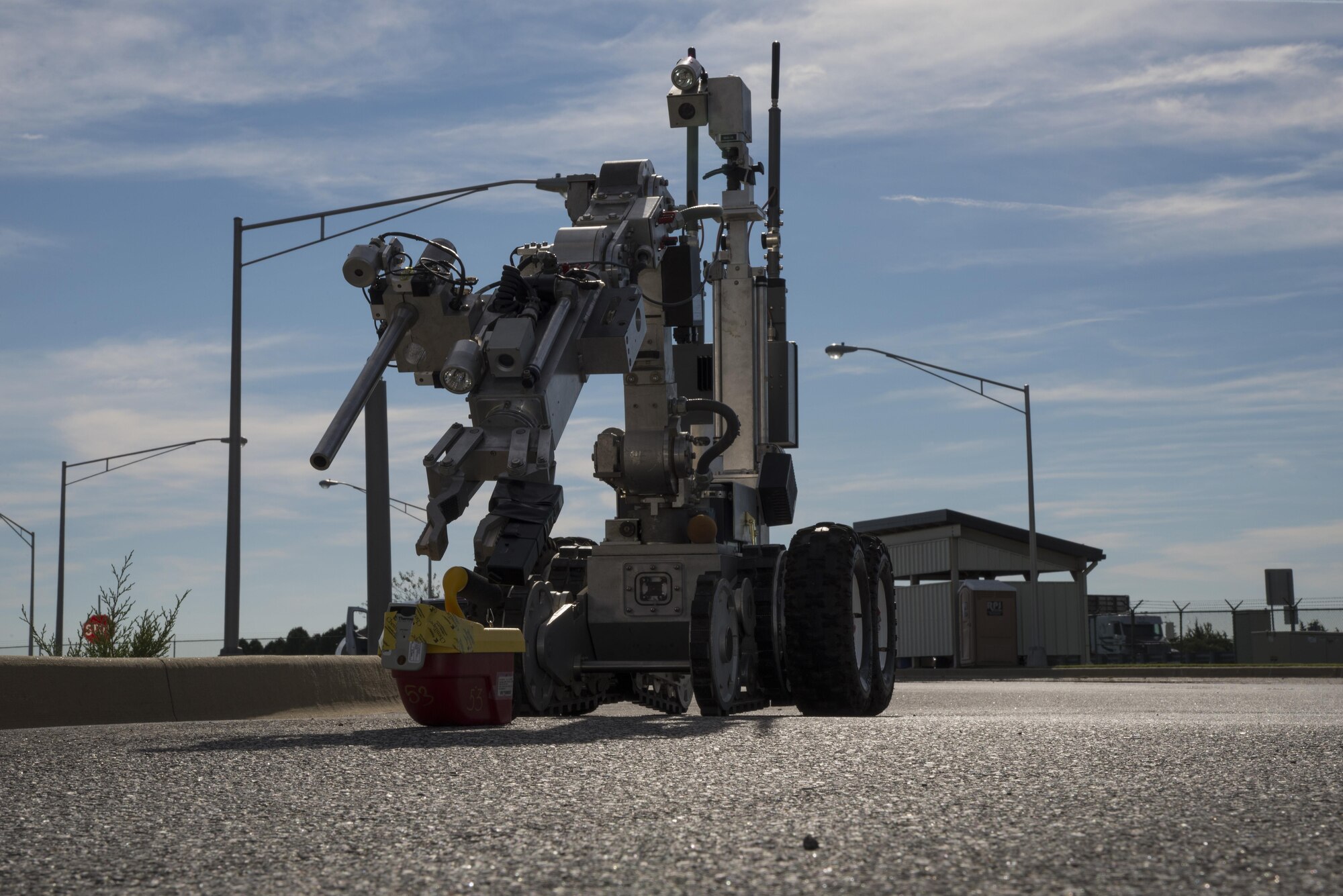 An F-6 explosive ordnance disposal robot, operated by members of the 436th Civil Engineer Squadron, picks up a radiation detector and personal dosimeter during a simulated radiological attack Oct. 26, 2016, at the south gate on Dover Air Force Base, Del. The red and yellow detector monitors and records x-ray and gamma radiation, while the personal dosimeter will trigger an alarm when harmful levels of radiation have been recorded. (U.S. Air Force photo by Senior Airman Aaron J. Jenne)