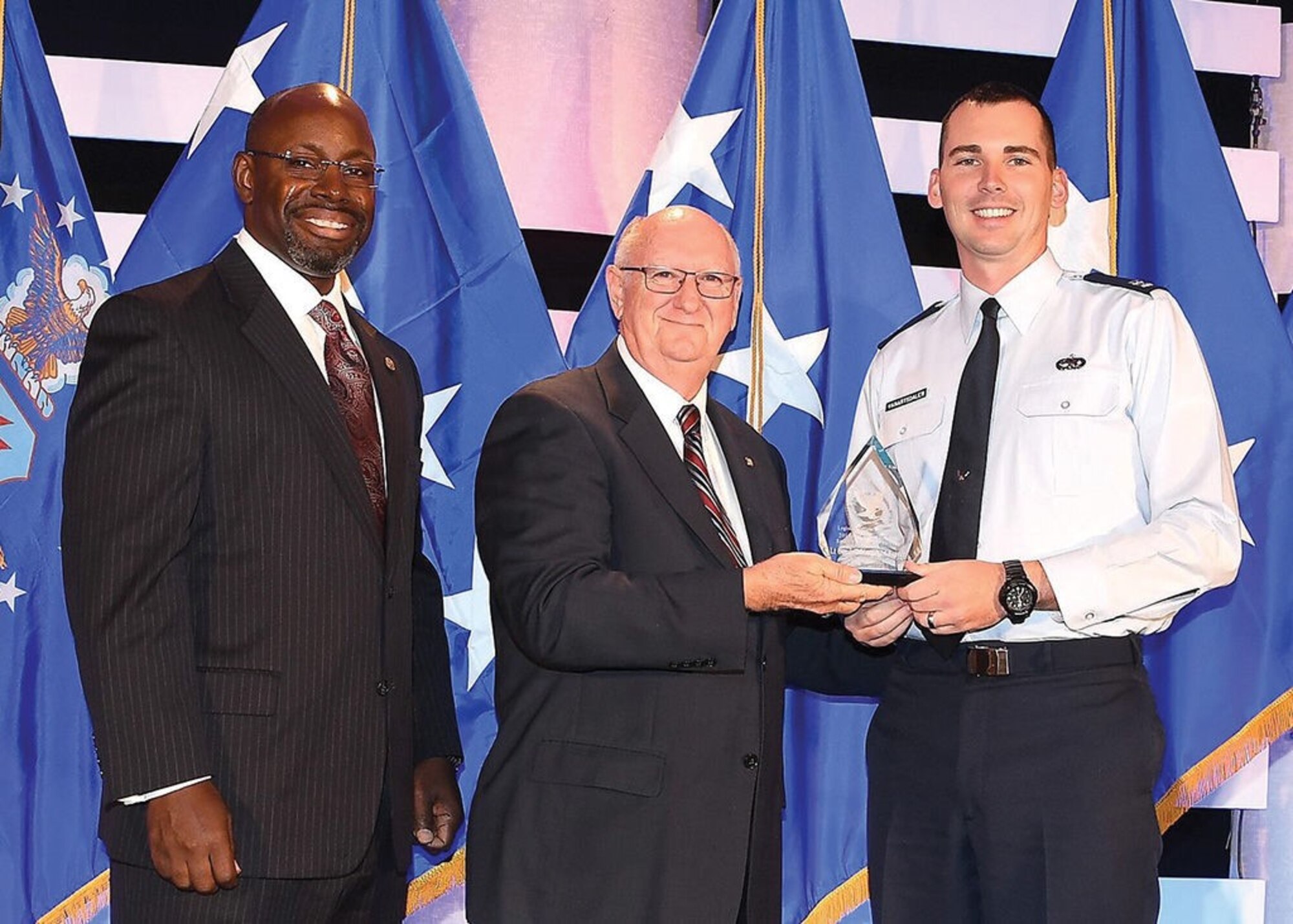 From left, retired Col. Dennis Dabny, retired Col. James Hass and Capt. Ryan VanArtsdalen pause on stage as Kirtland Air Force Base’s Logistics Officer Association Lt. Gen. Leo Marquez Chapter is recognized as the Small Chapter of the Year during the LOA symposium Oct. 11-14 in Washington, D.C. 