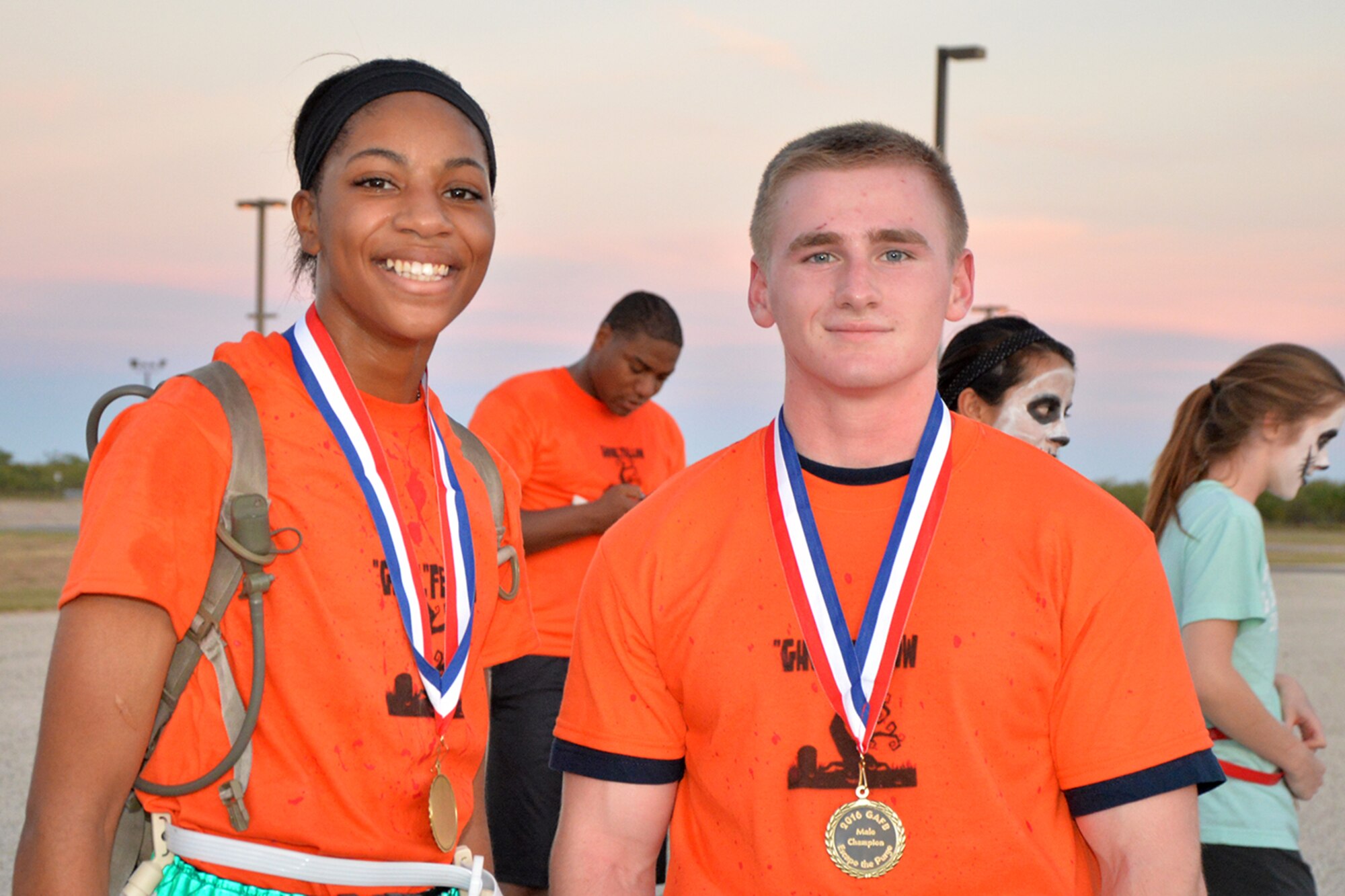 U.S. Army Pvt. Jayda James, 344th Military Intelligence Battalion student, and U.S. Air Force Airman Nicholas Trackwell, 312th Training Squadron student, display their medals after winning the purge 5k during Ghoulfellow on Goodfellow Air Force Base, Texas, Oct. 28, 2016. The runners with the fastest time and the most flags won the race. (U.S. Air Force photo by Airman 1st Class Randall Moose/Released)
