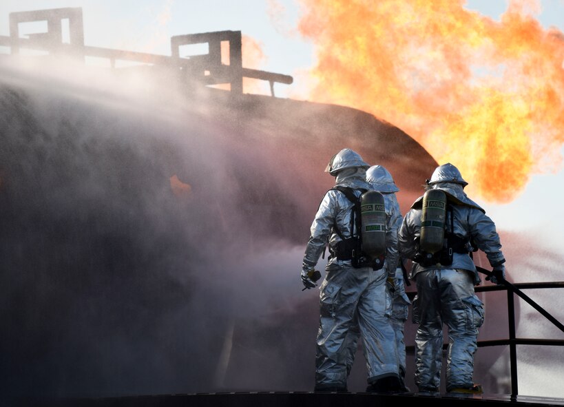 A crew of 2nd Civil Engineer firefighters prepare to enter a burning aircraft during an aircraft live fire burn at Barksdale Air Force Base, La., Oct. 26, 2016. A two-man crew consists of a nozzleman and crew chief, while a third is the instructor. (U.S. Air Force photo/Airman 1st Class Stuart Bright)