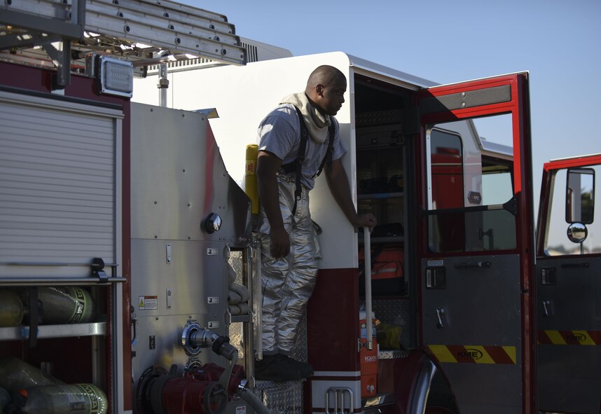 Senior Airman Clifton Watkins, 2nd Civil Engineer Squadron operator, stands on a fire engine at Barksdale Air Force Base, La., Oct. 27, 2016. The 2 CES firefighters conduct live fire burns semi-annually for training. (U.S. Air Force photo/Airman 1st Class Stuart Bright)