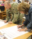 Col. Timothy Greenhaw, commander of the U.S. Army Environmental Command at Joint Base San Antonio-Fort Sam Houston, and Dr. Gail Siller, Fort Sam Houston Independent School District superintendent, sign the partnership agreement which renews the Adopt-a-School charter established in 2011.