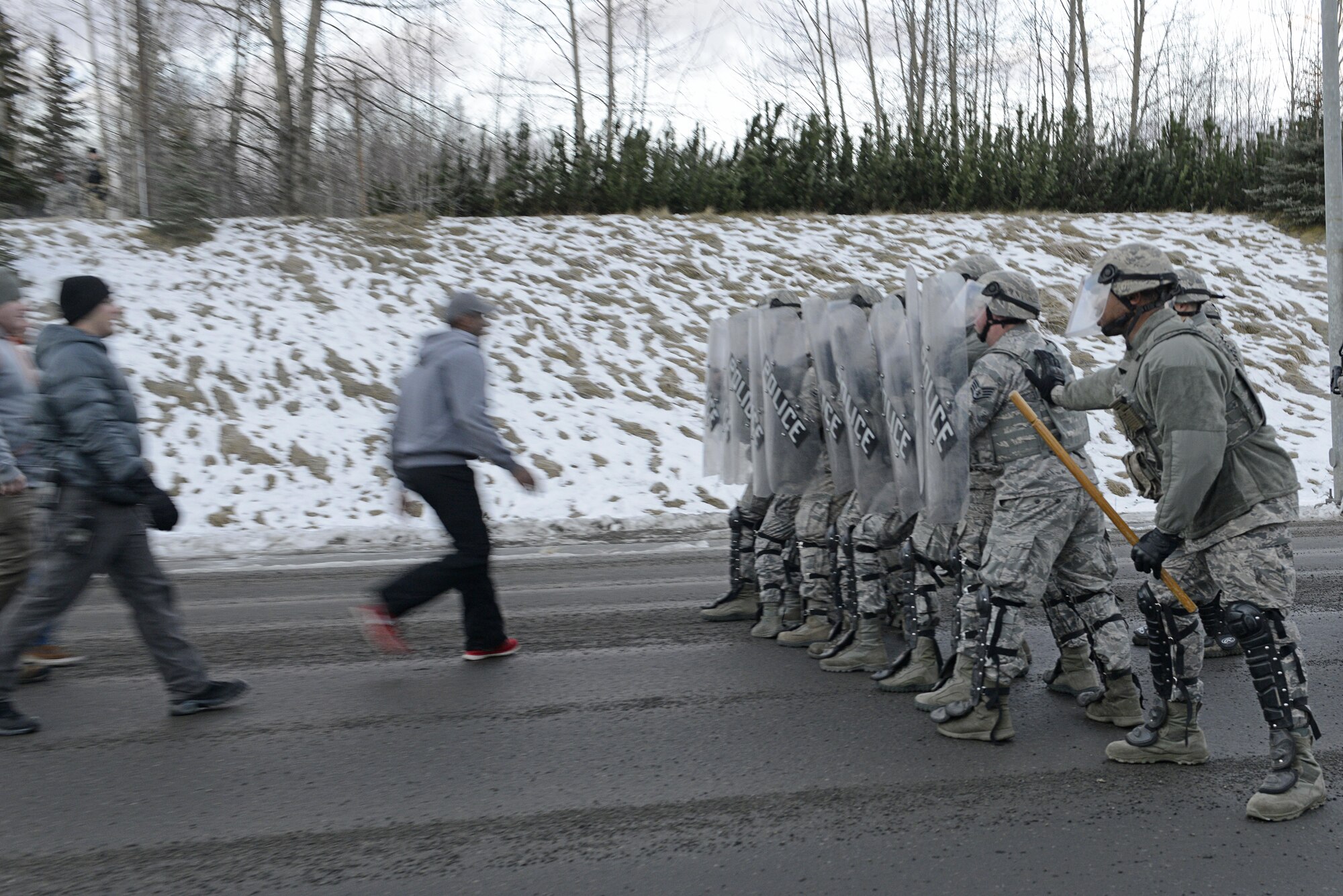 Joint Base Elmendorf-Richardson security forces personnel perform security operations during a simulated protest as part of exercise Polar Force 17-1 at JBER, Alaska, Nov. 1, 2016. The simulated protest began as a peaceful demonstration which escalated, resulting in a few aggressive protesters being detained and turned over to local law enforcement. The exercise tests the base's ability to integrate, mobilize, and prepare assigned personnel, aircraft and equipment for a wartime mission and to employ forces and weapons systems. 