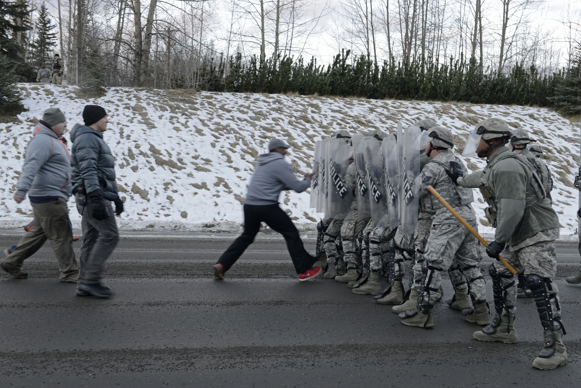 Joint Base Elmendorf-Richardson security forces personnel perform security operations during a simulated protest as part of exercise Polar Force 17-1 at JBER, Alaska, Nov. 1, 2016. The simulated protest began as a peaceful demonstration which escalated, resulting in a few aggressive protesters being detained and turned over to local law enforcement. The exercise tests the base's ability to integrate, mobilize, and prepare assigned personnel, aircraft and equipment for a wartime mission and to employ forces and weapons systems. 