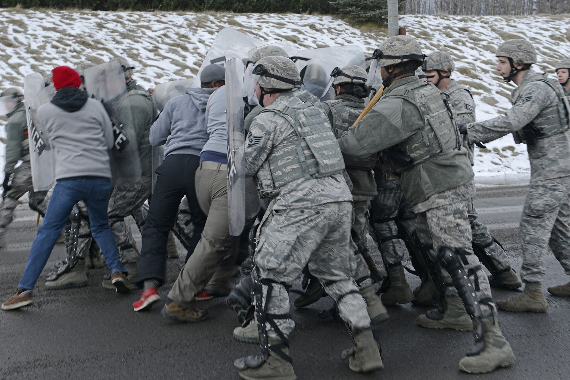 Joint Base Elmendorf-Richardson security forces personnel perform security operations during a simulated protest as part of exercise Polar Force 17-1 at JBER, Alaska, Nov. 1, 2016. The simulated protest began as a peaceful demonstration which escalated, resulting in a few aggressive protesters being detained and turned over to local law enforcement. The exercise tests the base's ability to integrate, mobilize, and prepare assigned personnel, aircraft and equipment for a wartime mission and to employ forces and weapons systems. 