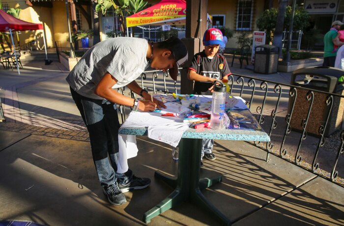 Participants decorate t-shirts before the mile and a half walk at the Make a Difference Day event at Marine Corps Recruit Depot San Diego, Oct. 22. The event was held to raise awareness for breast cancer and domestic violence. Booths for resources, activities and entertainment were set up to increase volunteerism among everyone.